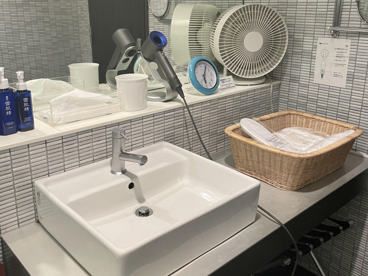 A circulator, hair dryer, and amenities are placed in the wash basin.